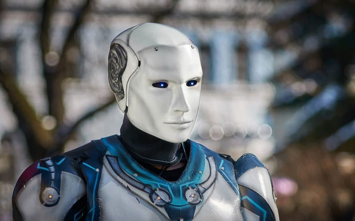 A humanoid robot with a sculpted face and blue-lit armour