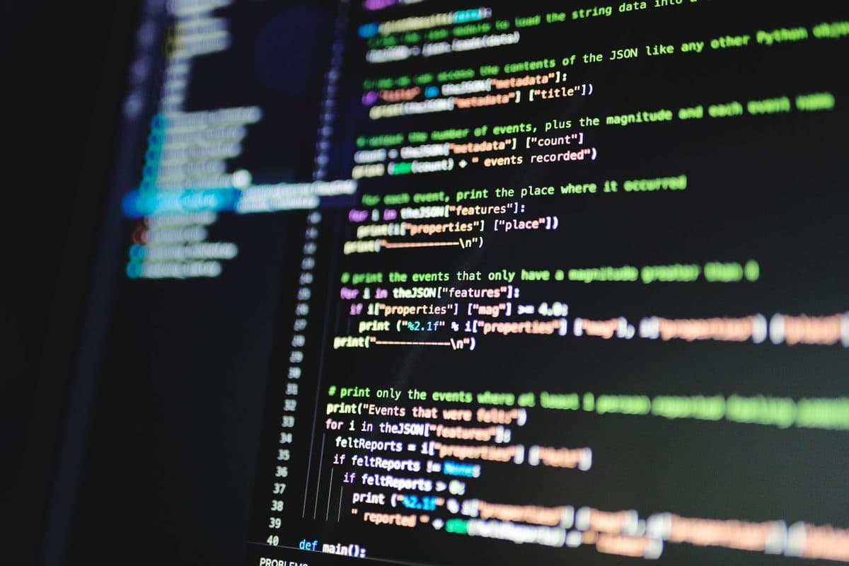 Colourful source code glowing on a dark computer screen