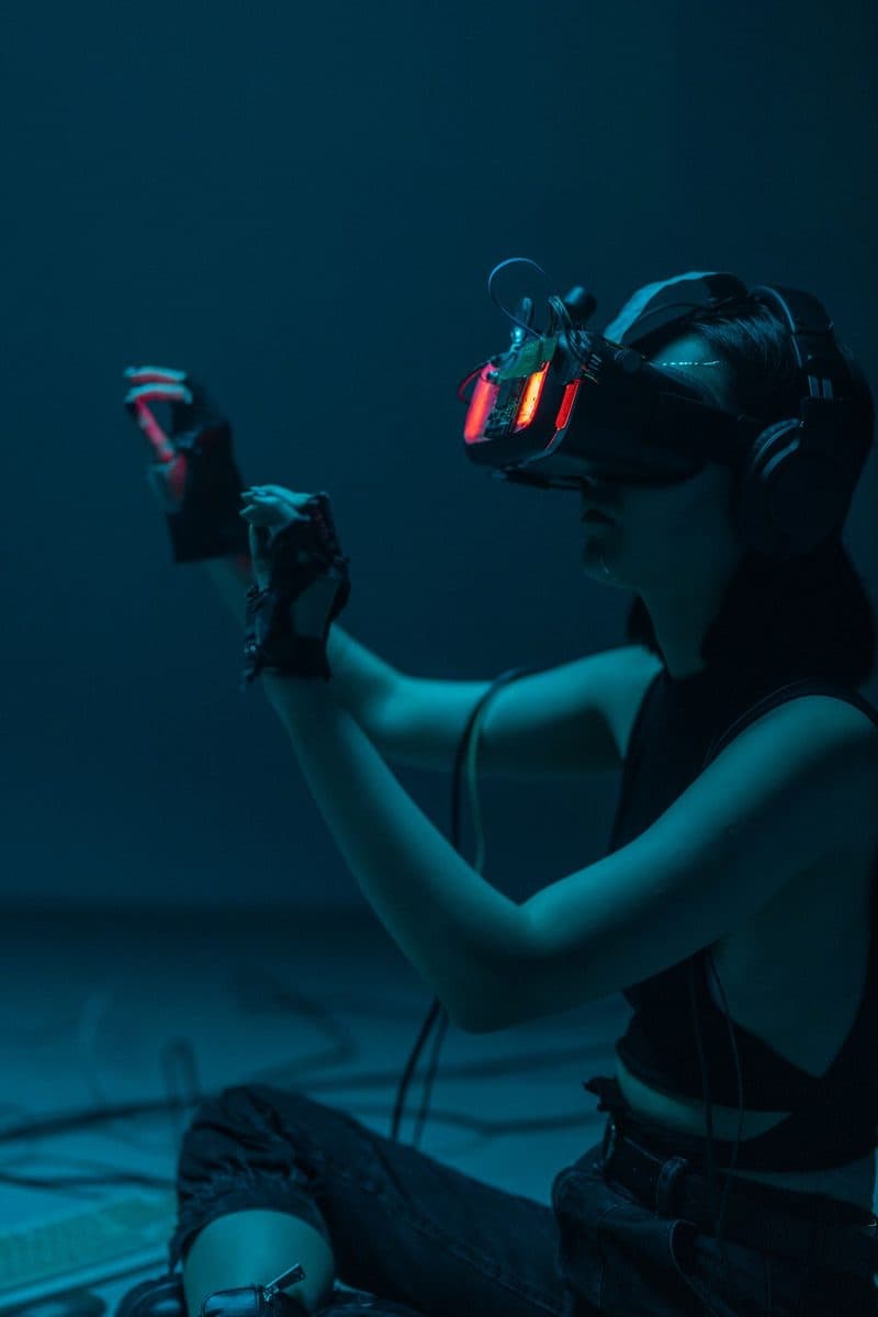 A person reaching out while wearing a glowing virtual-reality headset
