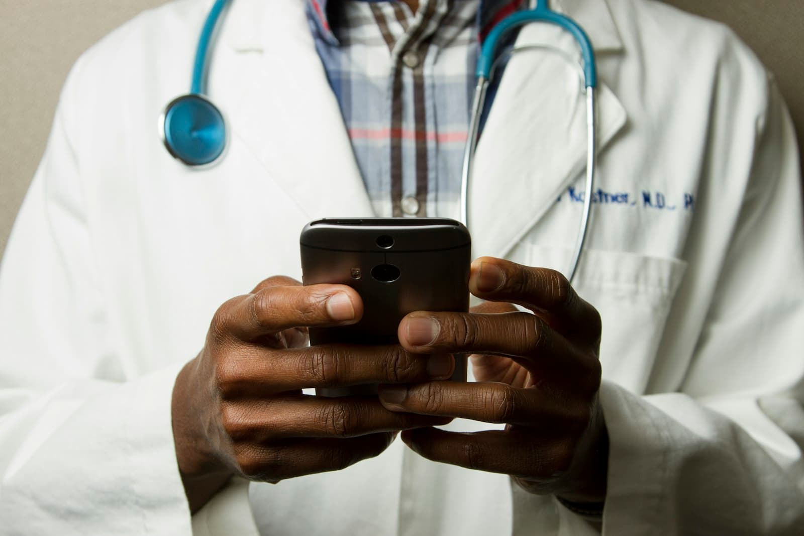 Clinicians in scrubs conferring over a tablet