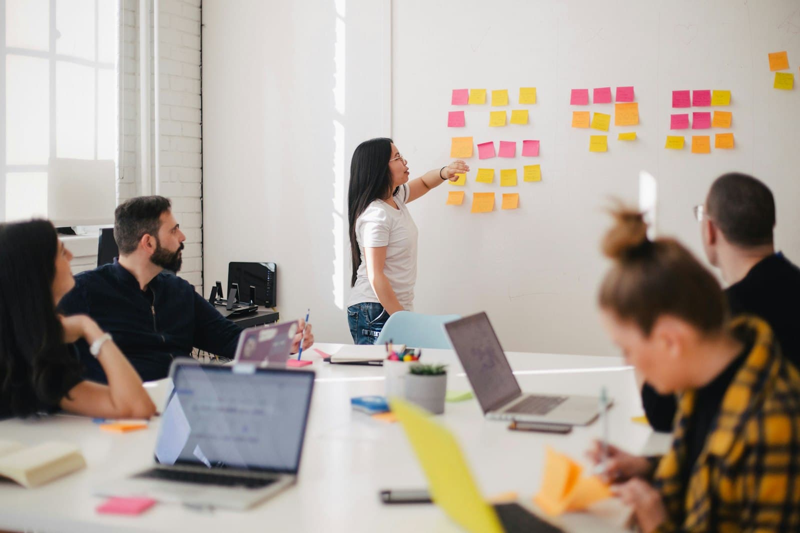 A team laughing together while planning with sticky notes in a bright studio